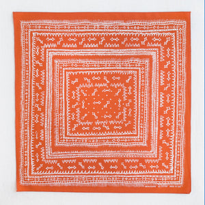 Marmalade orange bandana with white screen print. Print is a hand drawn series of sqaures which grow larger from the center. Small diamond shapes are in the center and edges.