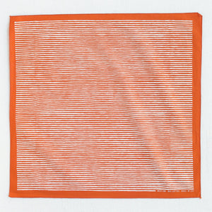 Burnt orange bandana with white striped screen print, shown open so the whole print is visible.